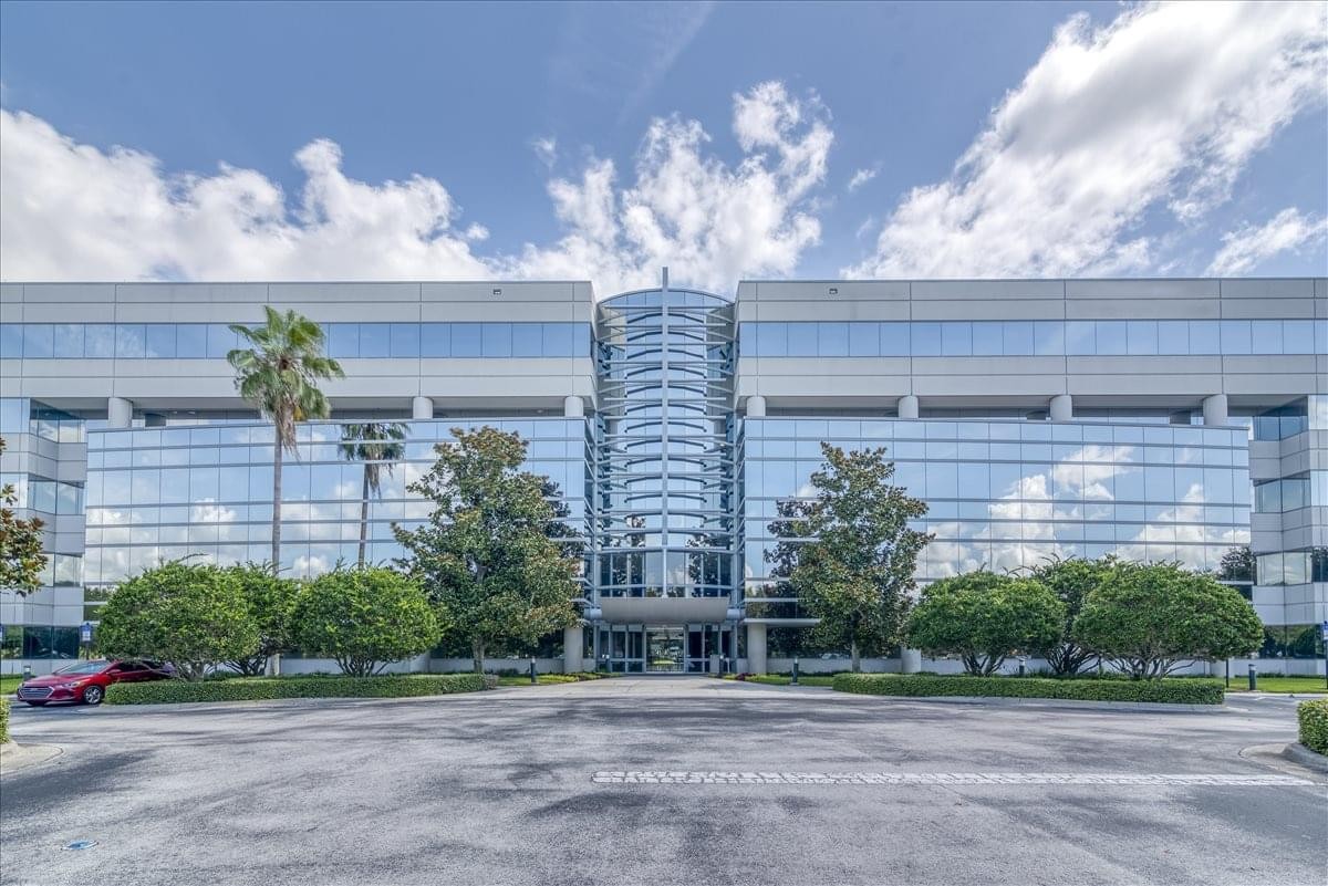 Exterior view of the glass-facade 801 International Parkway, Suite 500 building with palm trees.