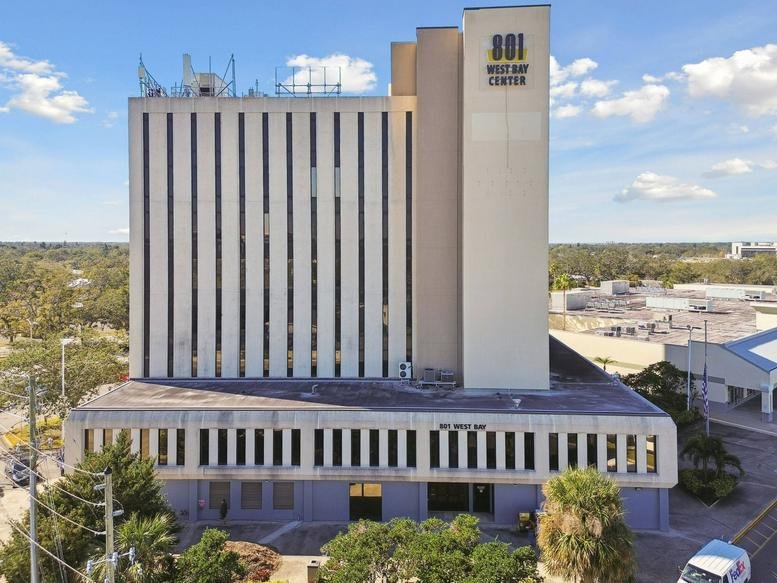 Exterior view of the multi-story 801 West Bay Center with a white facade and blue sky.