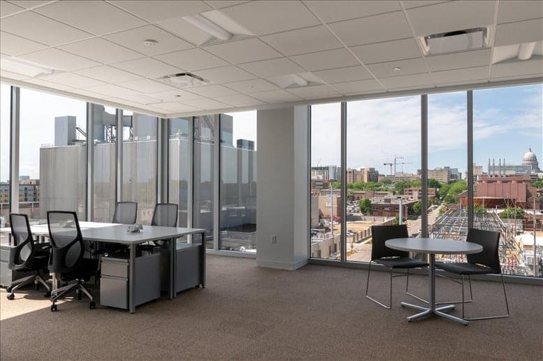 Open-plan workspace with multiple desks and city views.