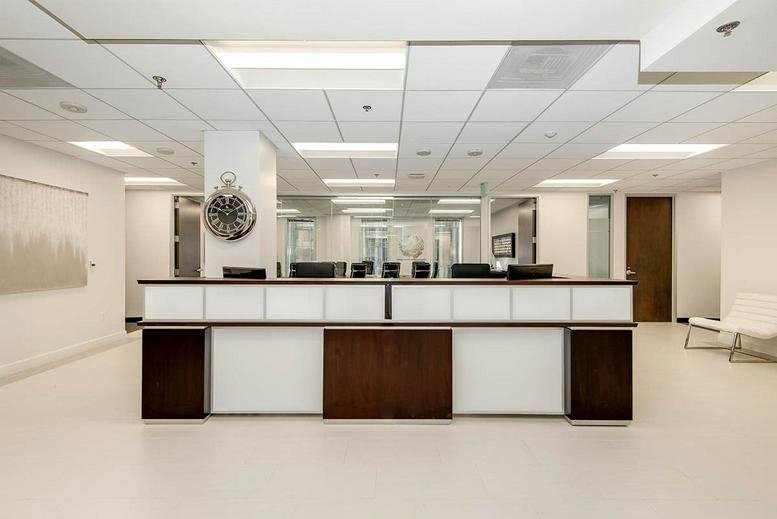 Symmetrical white reception desk with dark wood accents and a large wall clock.