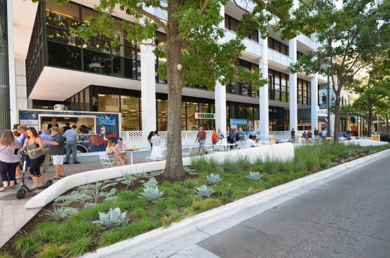 Exterior view of the white multi-story building at 823 Congress Avenue featuring street-level retail.