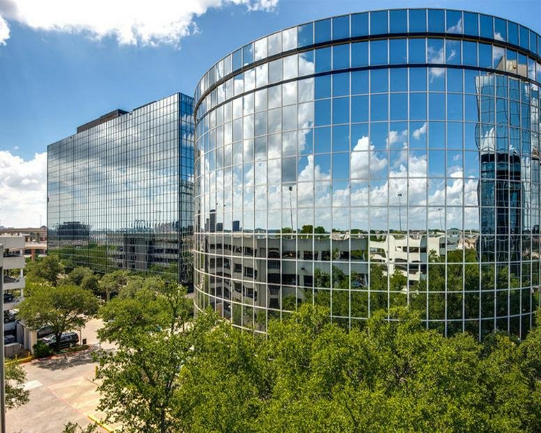 Exterior view of the curved glass-facade building at 8330-8360 LBJ Freeway.