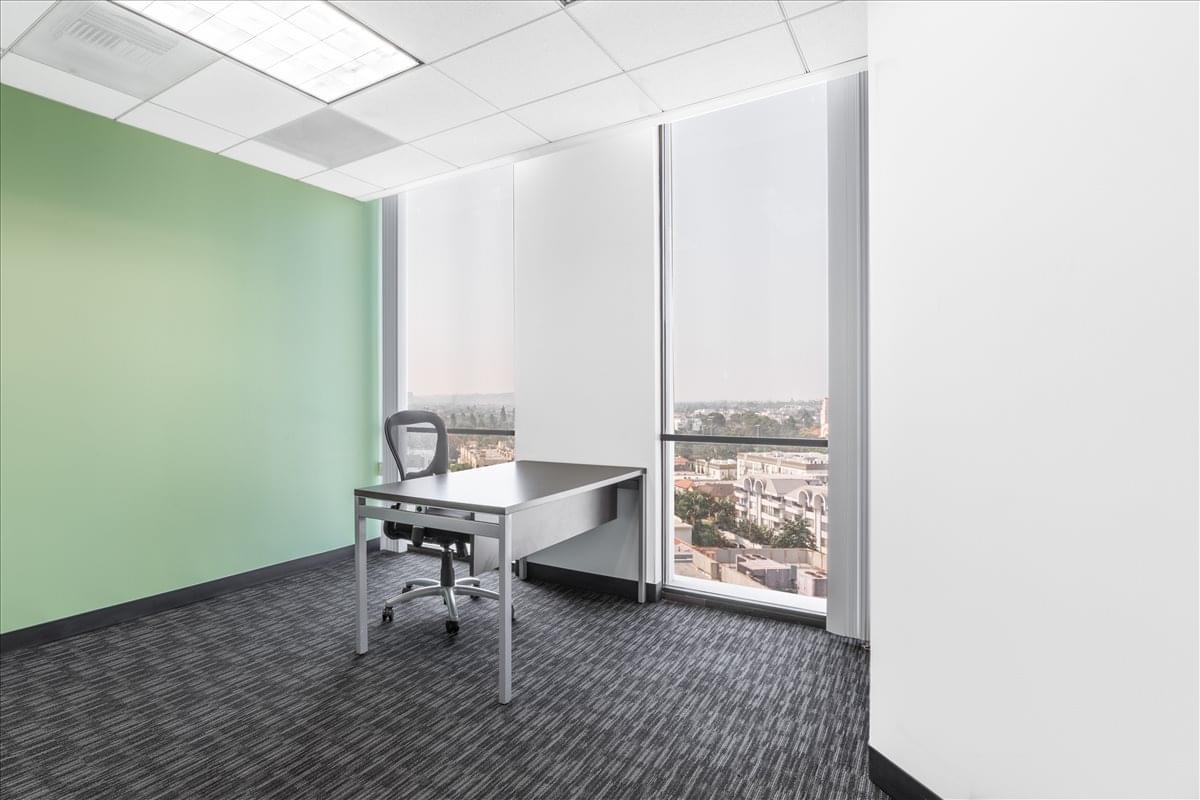 Bright private office at 8383 Wilshire Blvd, Suite 800, featuring a sage green accent wall and city views.