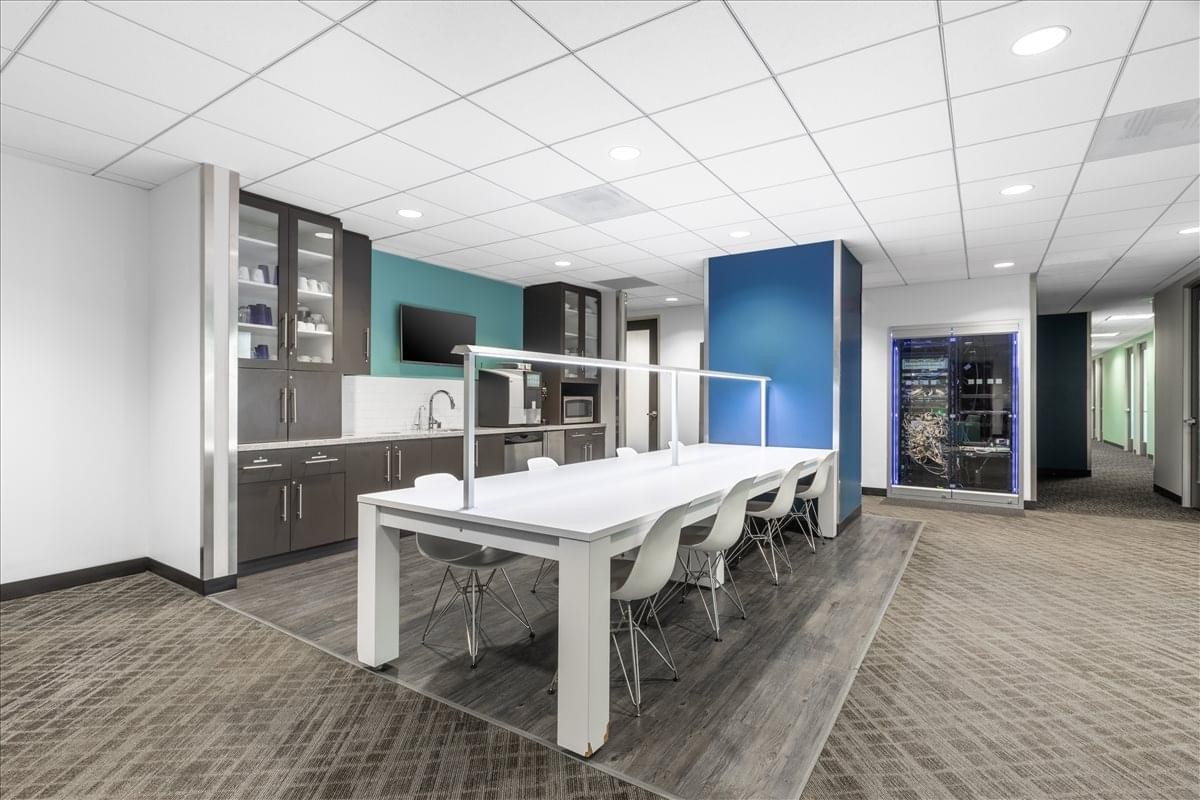 Large communal breakout area at 8383 Wilshire Blvd, Suite 800 with a long white table and kitchen facilities.