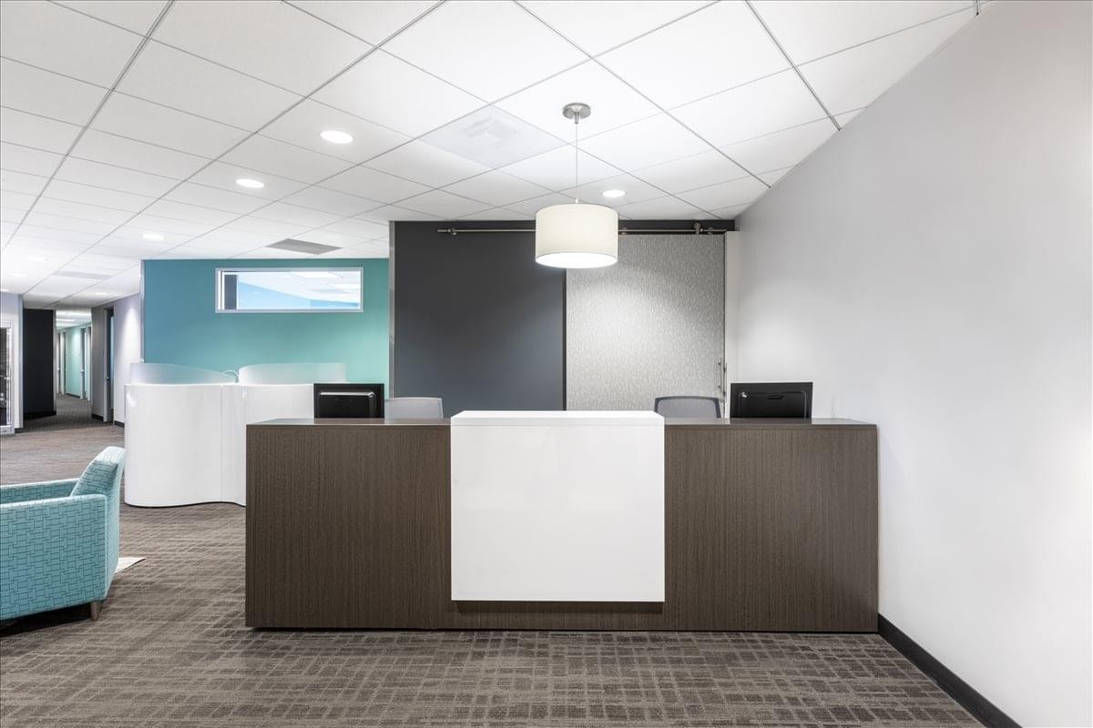 Professional reception area at 8383 Wilshire Blvd, Suite 800 with a dark wood desk.