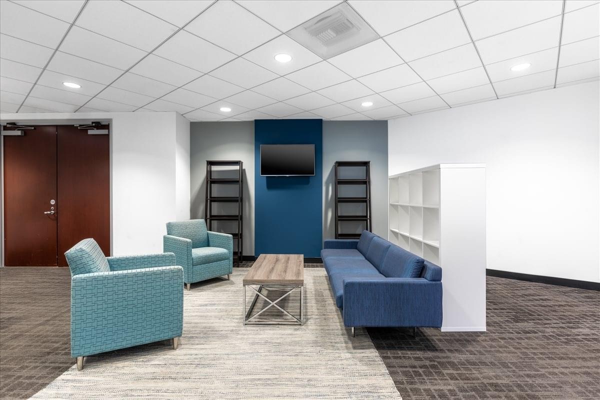 Spacious lounge with blue armchairs, a matching sofa, and a wood coffee table.