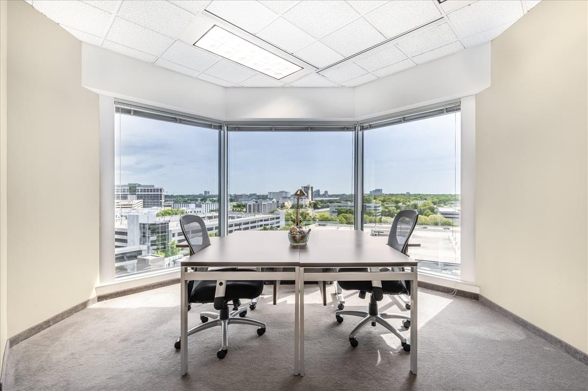 Meeting space for four at 8400 Normandale Lake Boulevard with panoramic city views through floor-to-ceiling windows.