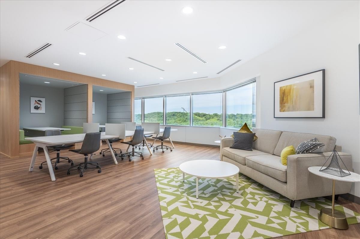 Modern lounge area at 8400 Normandale Lake Boulevard with a sofa and green patterned rug.