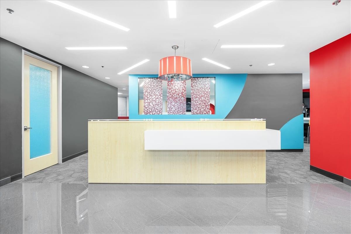Bright reception area at 8403 Colesville Road, Suite 1100 with a light wood desk and colorful back wall.
