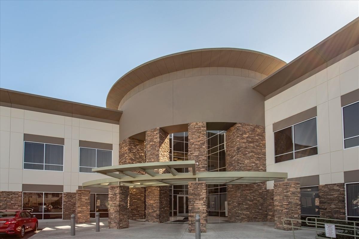 Exterior entrance of Siena Office Park Center I with stone pillars and a curved architectural facade.