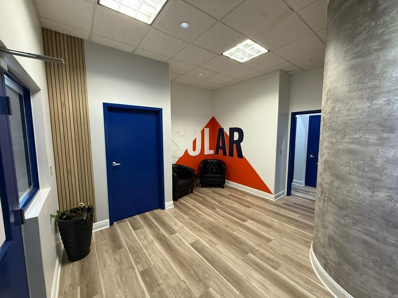 Spacious reception hallway at GR Realty Experts Co-Working Offices with wood floors and branded wall art.