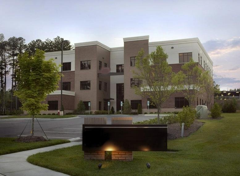 Exterior view of the multi-story brick and stone building at 8801 Fast Park Drive, Suite 301.
