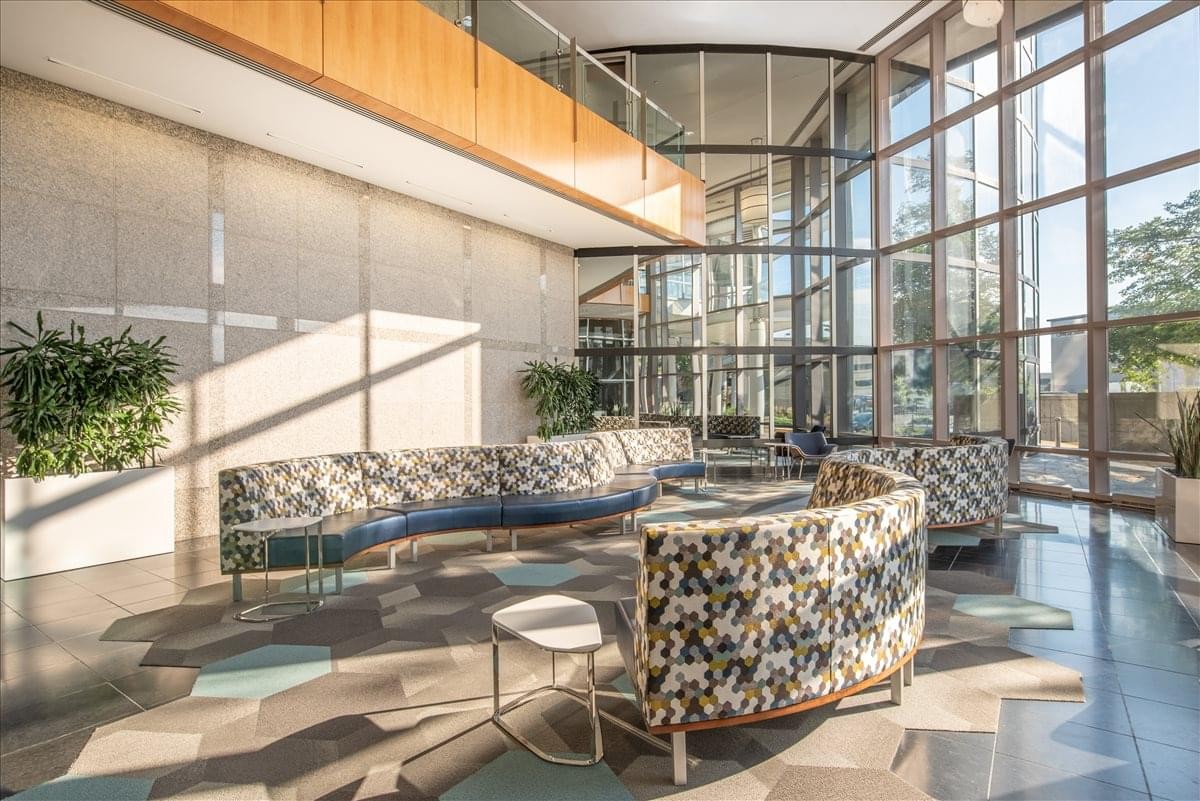 Spacious lobby with high ceilings, floor-to-ceiling glass walls, and patterned curved sofas at 8888 Keystone Crossing.