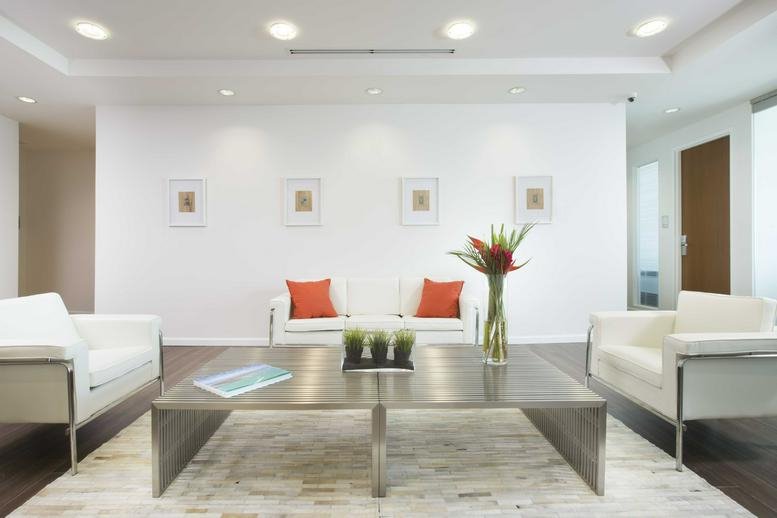 Bright reception area at 8950 SW 74 Court, Suite 2201 with white seating and orange accents.