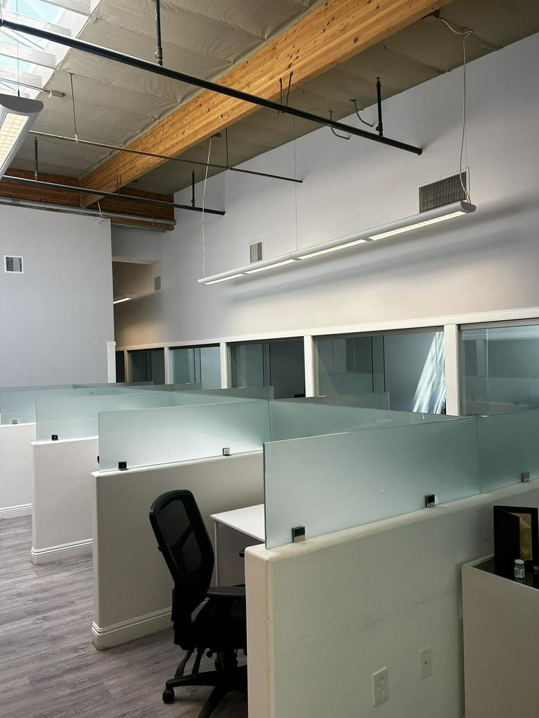 Modern open-plan workspace at The Exchange, 90 Discovery, Irvine, California with frosted glass privacy partitions.