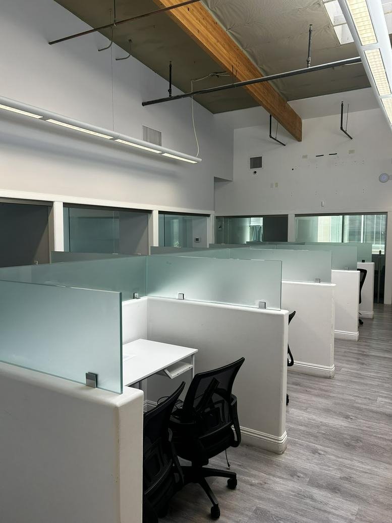 Spacious workstation area at The Exchange, 90 Discovery featuring modern glass-topped dividers.