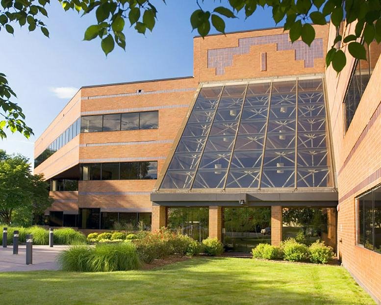 Entrance of 90 East Halsey Road with a prominent glass atrium and manicured green lawn.