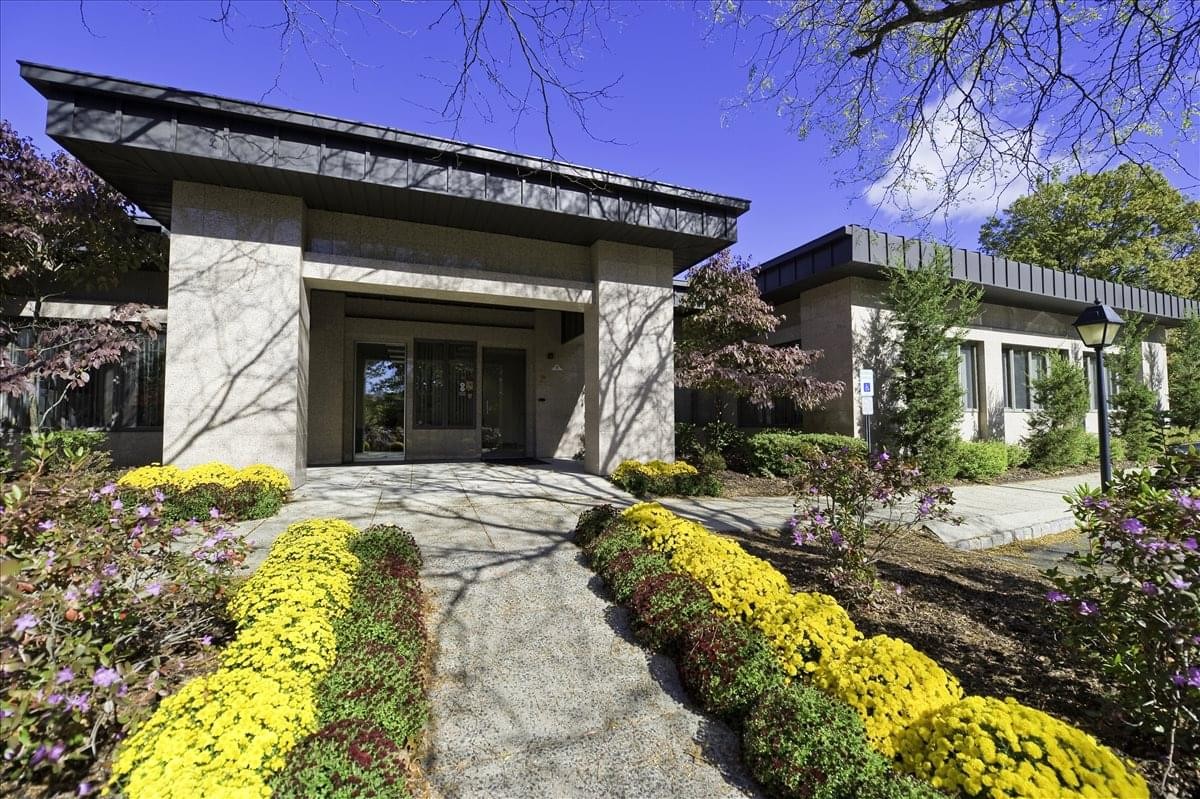 Exterior view of the stone facade and landscaped entrance at 90 Washington Valley Road, Washington Valley Center.