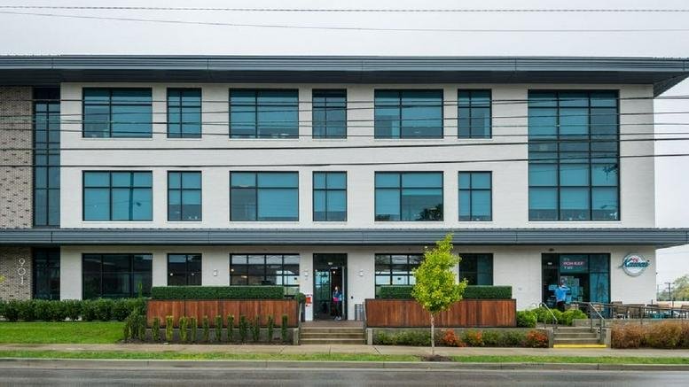 Modern three-story exterior of 901 Woodland Street with large windows and manicured landscaping.
