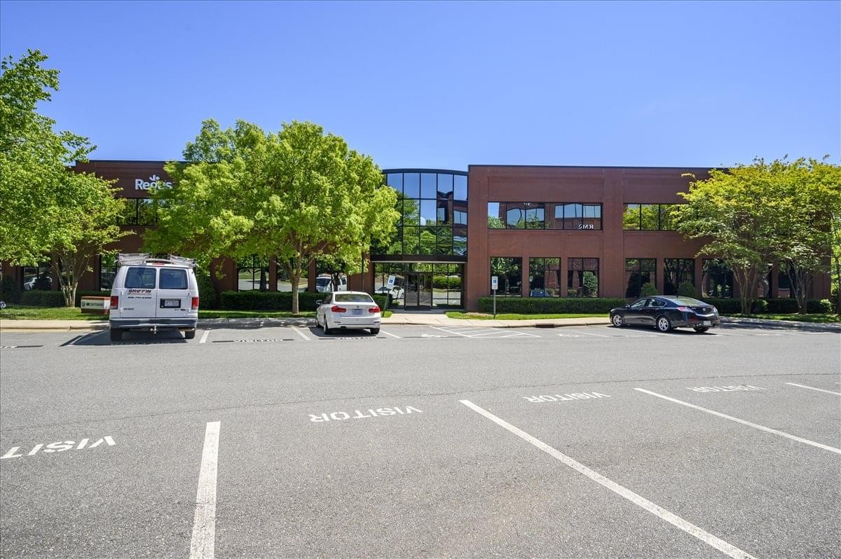 Exterior view of the brick facade and landscaped grounds at 9121 Anson Way, Suite 200.
