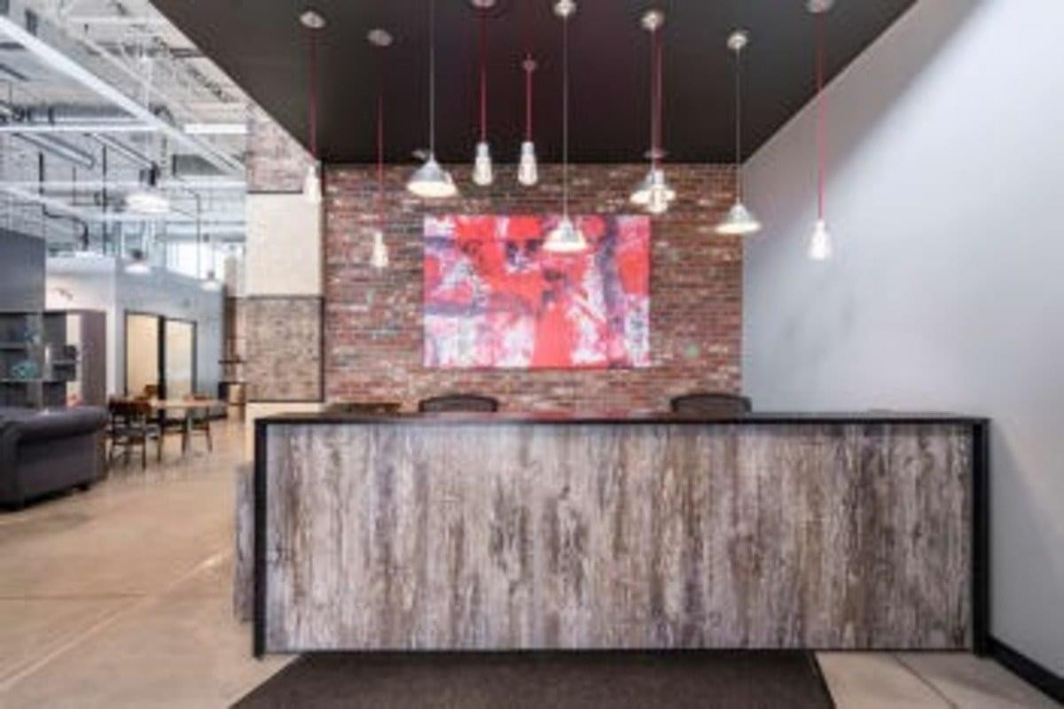 Reception desk at Keele Rutherford Corporate Centre with wood paneling and a vibrant red abstract painting.