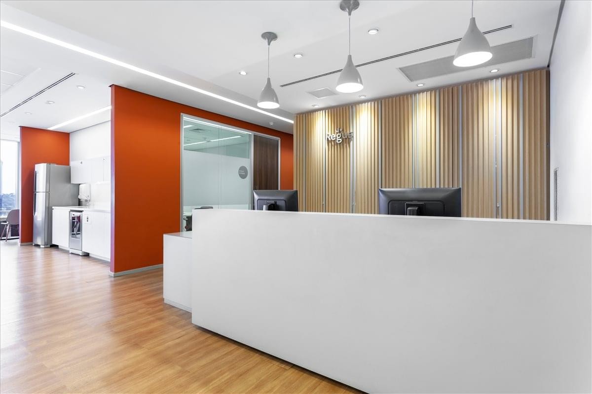 Modern reception area with a minimalist white desk and warm wood-paneled feature wall.