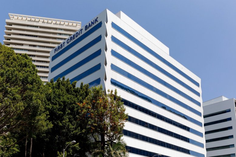 Exterior view of the white facade and blue windows of the First Credit Bank building at 9255 Sunset Boulevard.