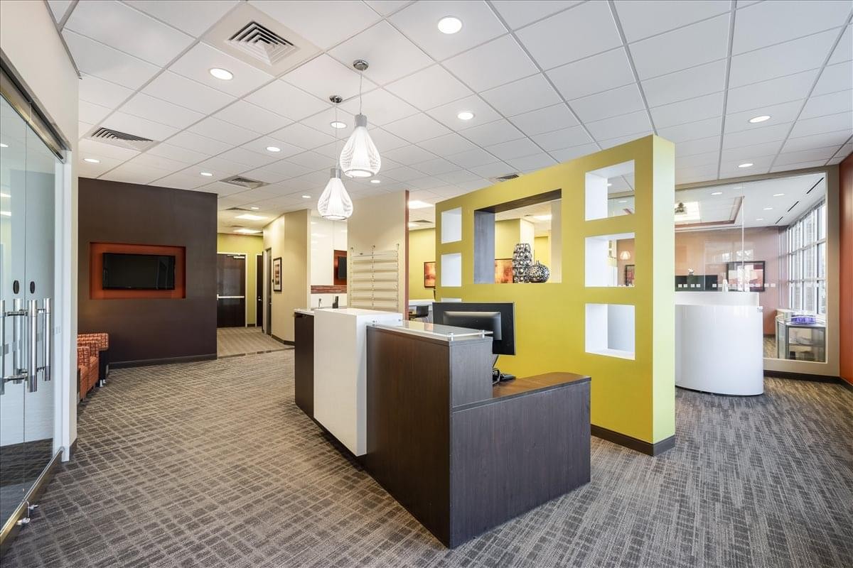 Modern reception area at 950 E. State Highway 114 featuring a bright yellow accent wall and stylish pendant lights.