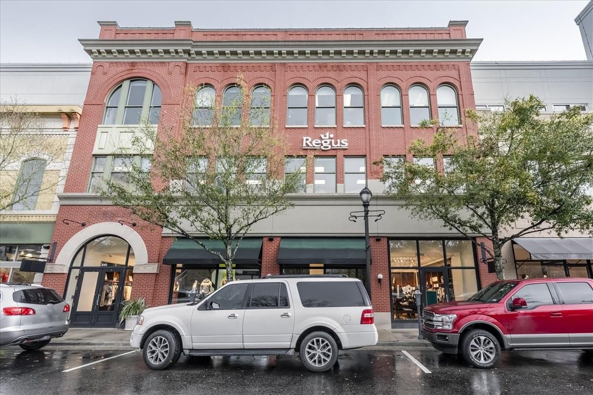 Exterior view of the red brick 9595 Six Pines, Building 8 building with ground floor retail.