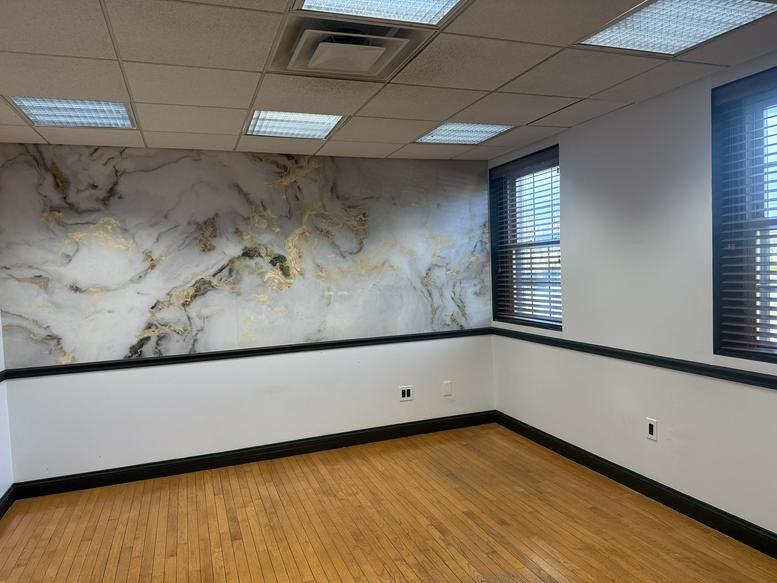 Private office featuring a marble-patterned feature wall and hardwood floors at 960 Reservoir Avenue, Unit 27.