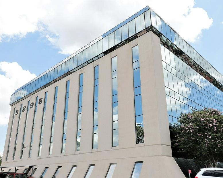 Exterior view of the multi-story glass and concrete office building at 9896 Bissonnet.