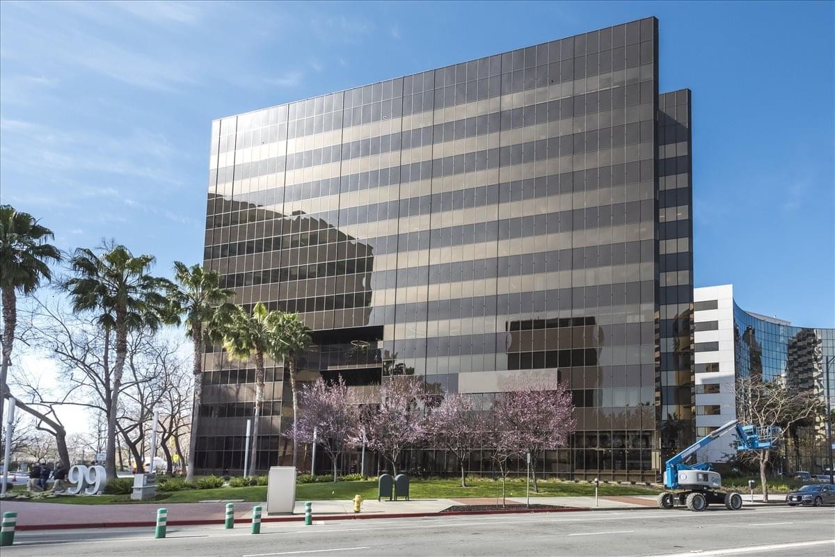Exterior view of the dark glass and brown paneled office building at 99 Almaden Blvd.