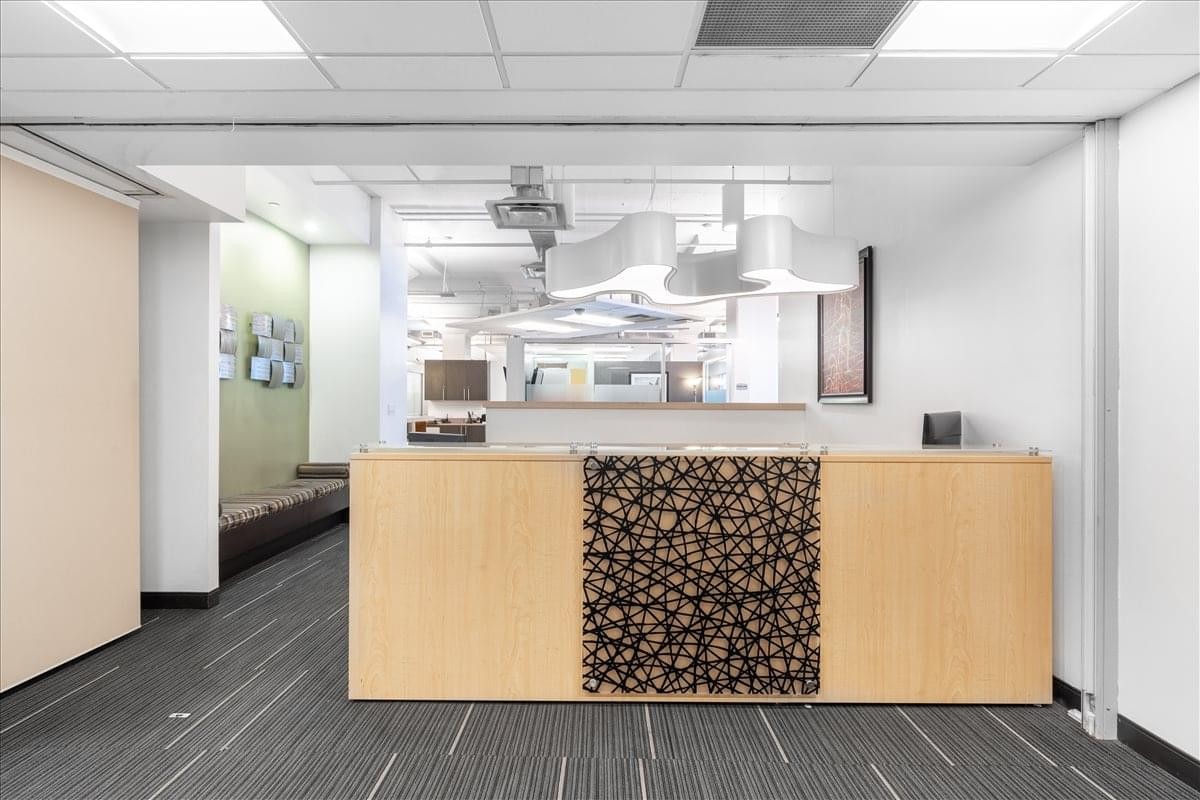 Modern reception area at 99 Hudson Street with a decorative wood-patterned front desk.