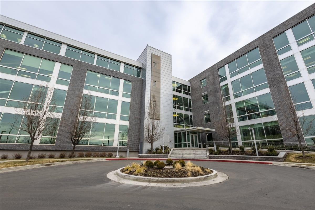 Exterior view of the modern glass and stone building at 9980 South 300 West, Suite 200.