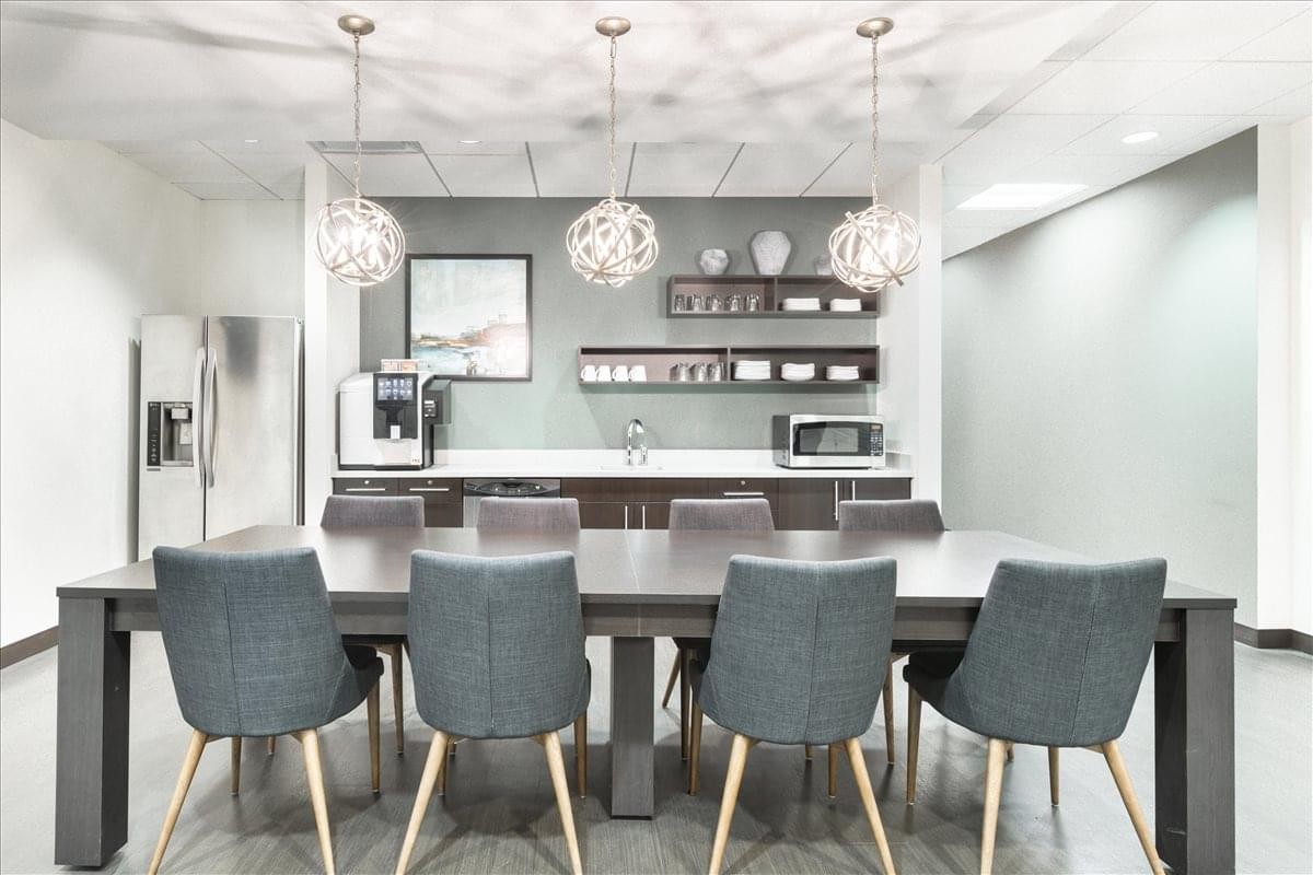 Kitchen and breakout area at Aksarben Village, 2111 South 67th Street, featuring orb pendant lights.
