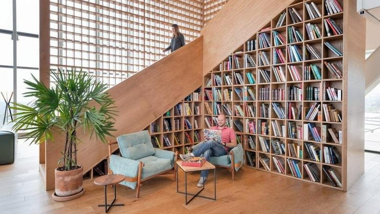 Spacious communal lounge at Artz Pedregal, Blvd Adolfo Ruiz Cortines 3720, featuring a large under-stair bookshelf.