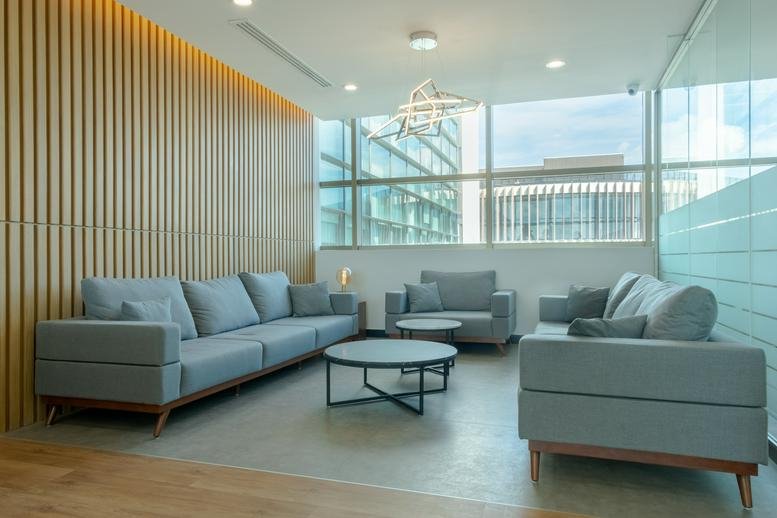 Lounge area with gray sofas, a wood-slat feature wall, and large windows at Av. Acanceh Manzana 2 Lote 3 Piso 3-B.