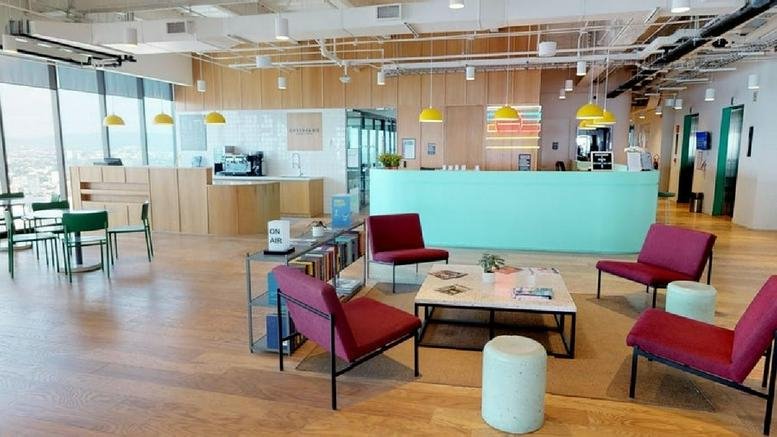 Spacious reception and lounge at Av Adolfo López Mateos Nte 95 featuring teal desks and red armchairs.