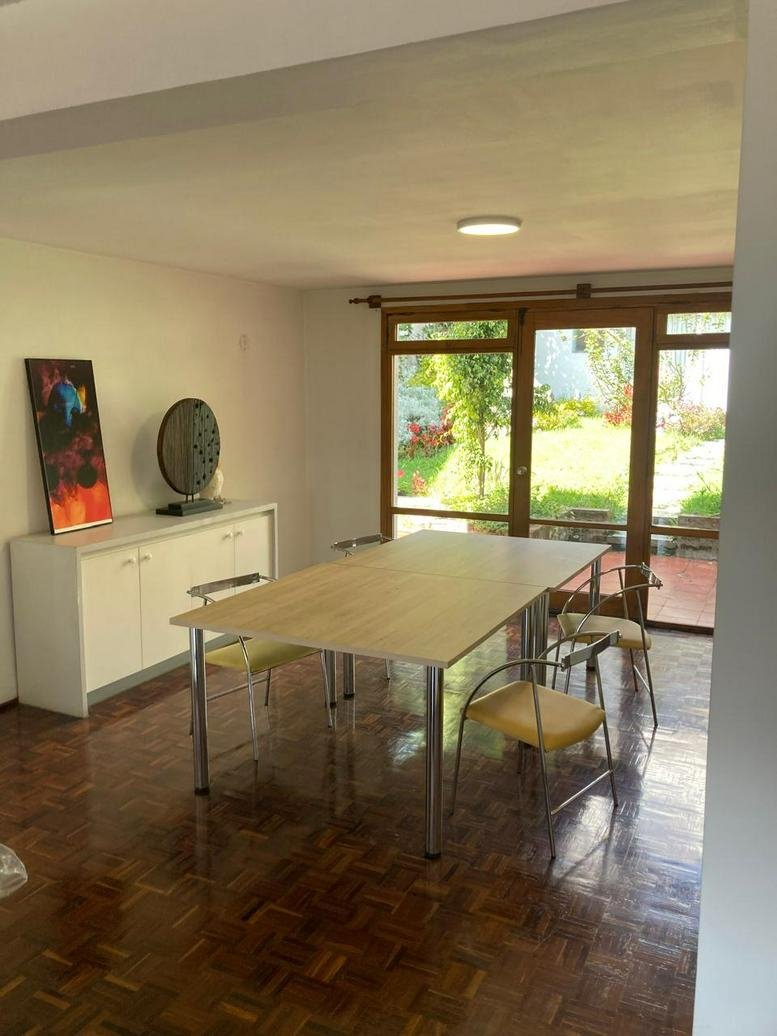Bright meeting room at Colibrí Garden Haus with a large light wood table and garden views.