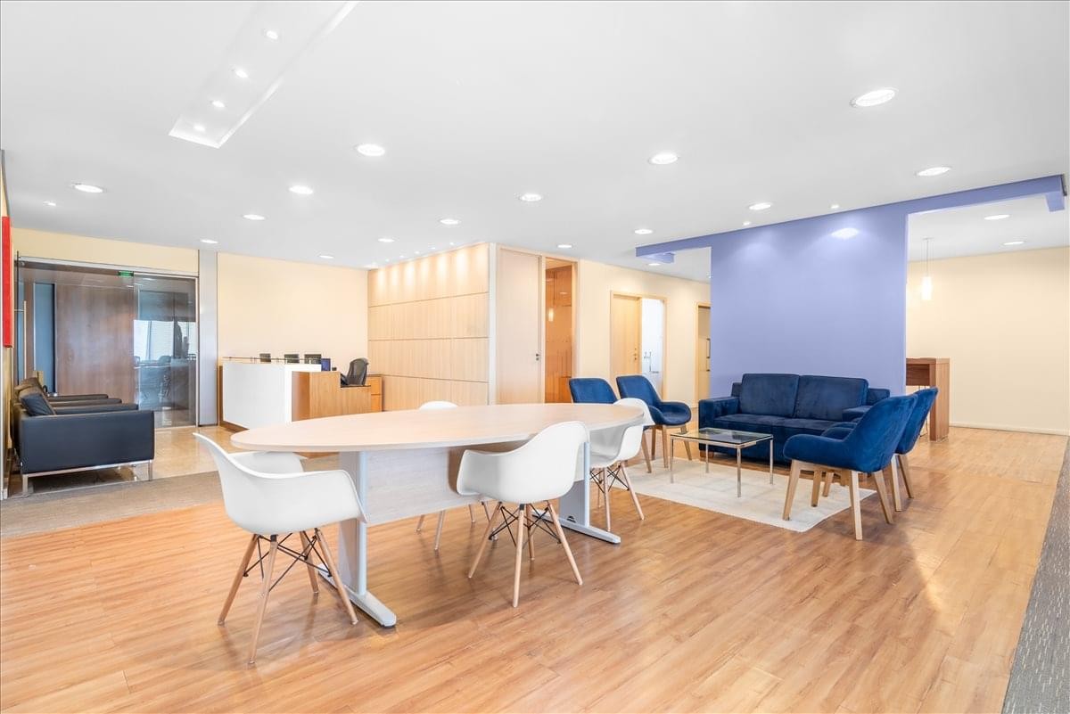 Lounge and reception area featuring a blue accent wall, navy sofas, and white designer chairs.