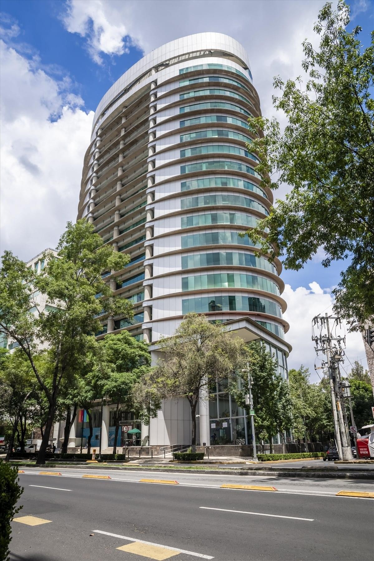 Exterior view of the curved glass facade of Av. Insurgentes Sur 1898.