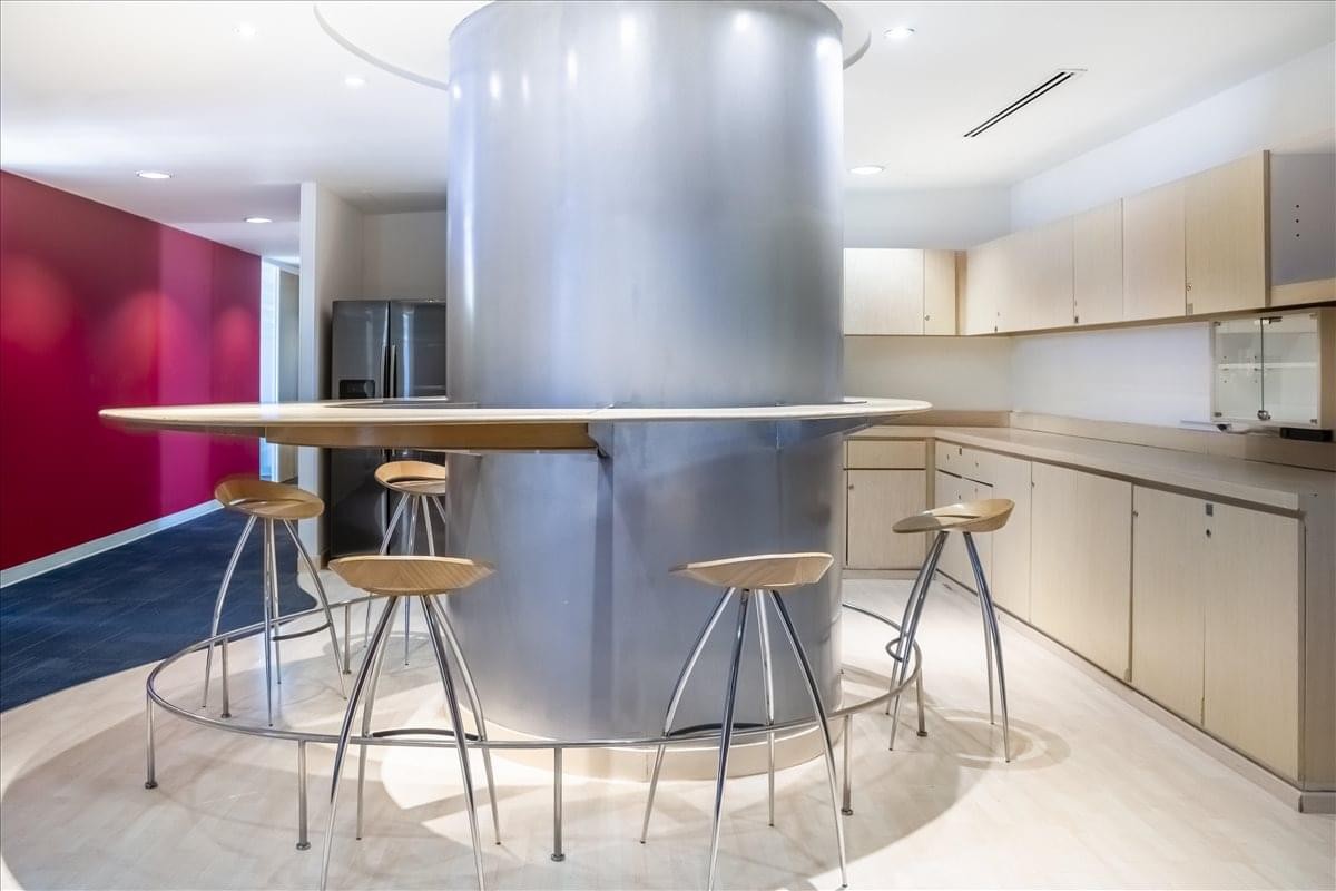 Modern communal kitchen area with a circular breakfast bar and sleek silver accents.