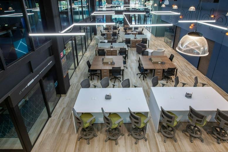 Elevated view of a modern open-plan office at Av. Insurgentes Sur No. 105 showing various workspaces.