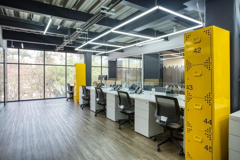 Spacious interior office view of Av. Jinetes No. 7, piso 2. Col. Arboledas with yellow accent lockers.