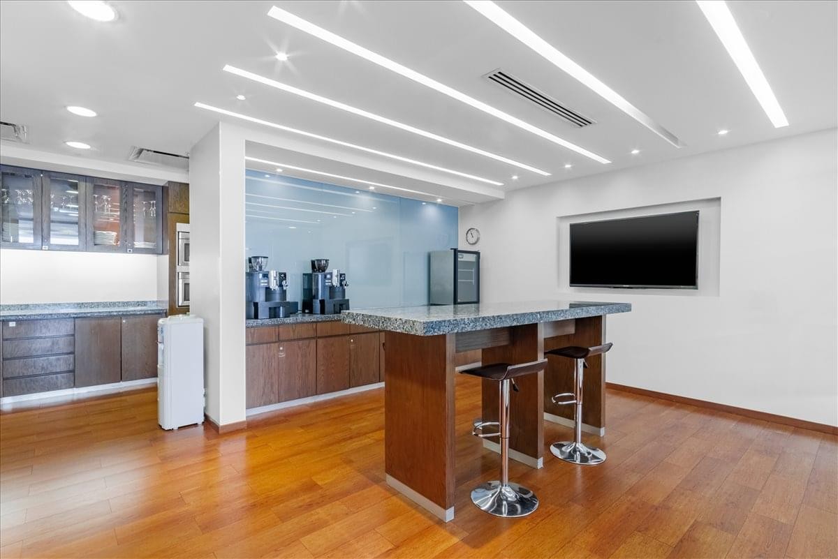 Modern breakroom area at Terret Polanco with a high table, bar stools, and coffee station.