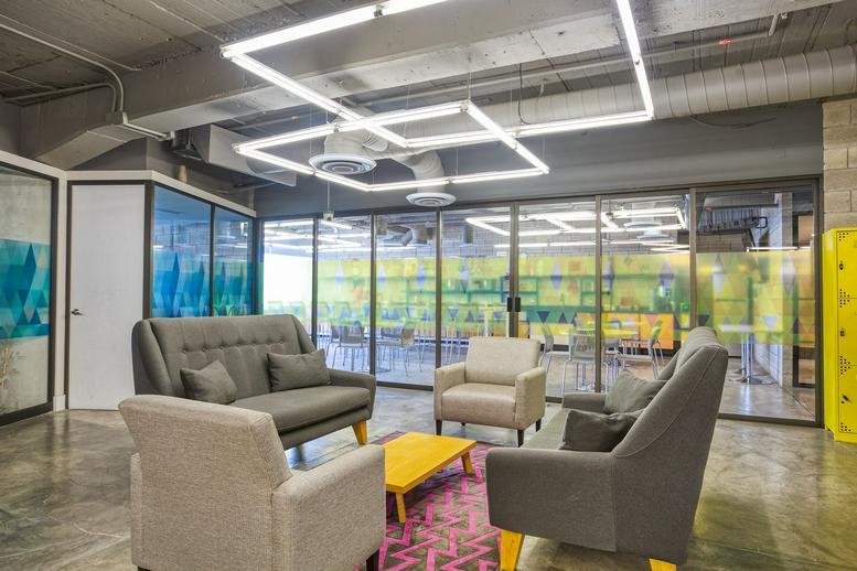 Lounge area at Av. Rodolfo Gaona No. 3 with grey sofas and square overhead lighting.