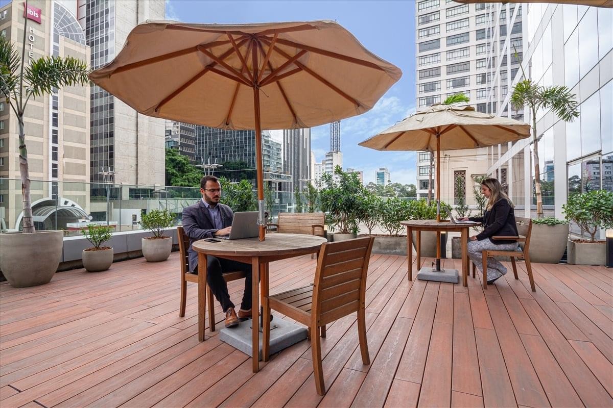 Spacious outdoor terrace at Avenida Paulista 2. 300, andar Pilotis, Sao Paulo, Brazil with wooden decking and umbrellas.