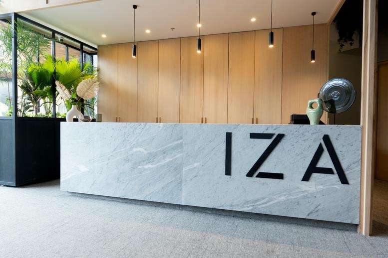 Reception area at Urban Center Cancún, Avenida Tulum Sur, featuring a marble desk with IZA branding.