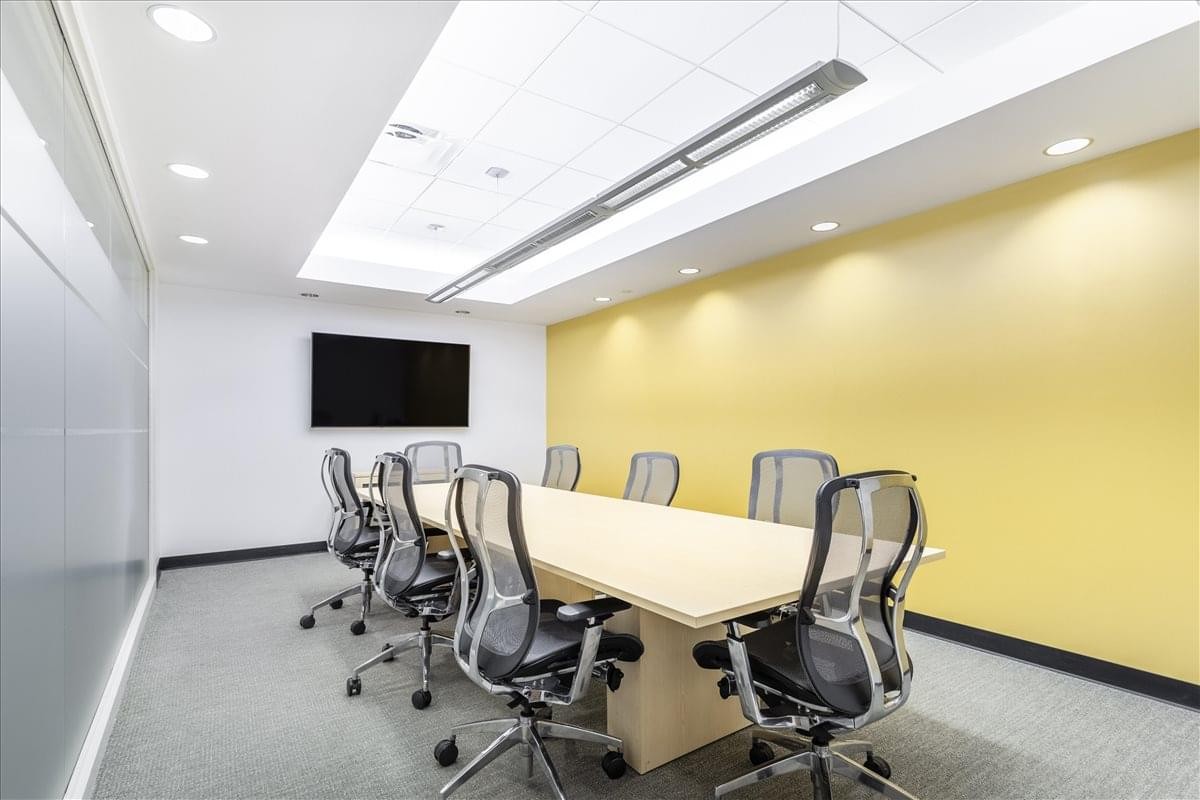 Professional boardroom at Calder Plaza, Downtown Grand Rapids, with a yellow accent wall.