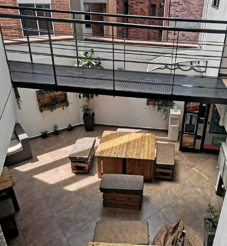 Outdoor terrace at Calle 34 B No. 65 D 02, Suite 201, featuring pallet-style wooden furniture and a metal walkway.